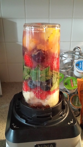 colorful fruit and veggies in the blender ready to mix