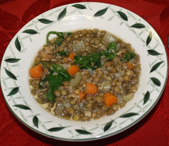 A bowl with decorative leaves painted on the rim and filled with lentil soup.