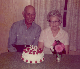 An older couple with a birthday cake on her 80th birthday