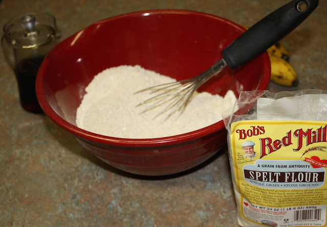 a bowl of spelt flour with a whisk to stir it so that the finished product is airy and light