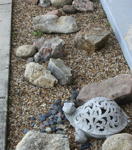 Rocks and weatherproof decorations make for an attractive flowerbed.