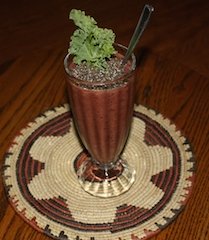 smoothie with a generous topping of chia seeds, garnished with leaf of kale