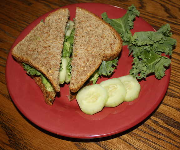 A tasty avocado cucumber sandwich with kale on sprouted grain bread