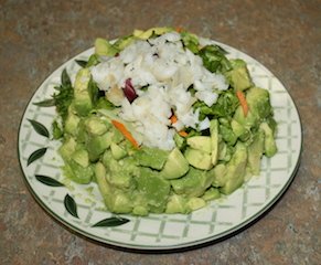 this is the finished avocado salad topped with flaky white fish, before dressing or sauce is added