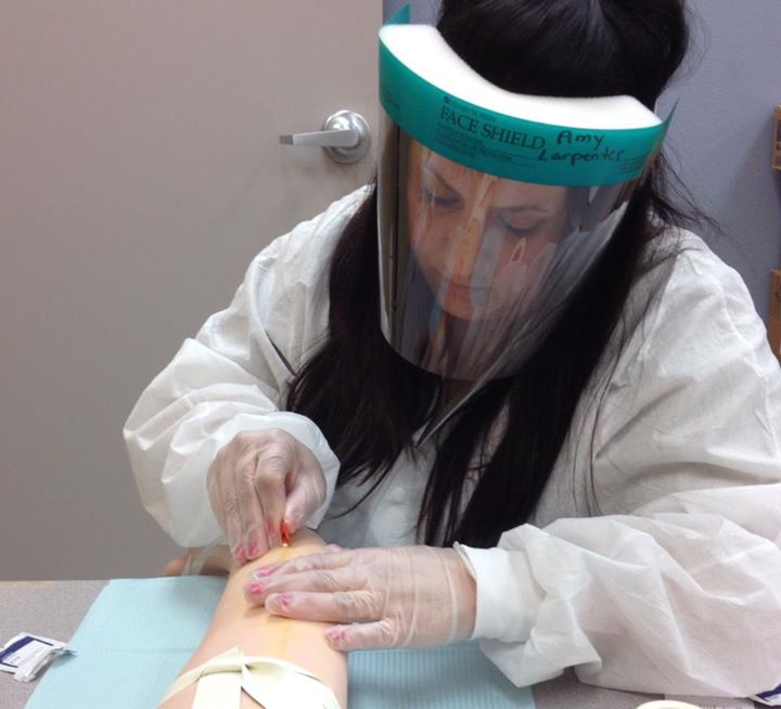 dialysis technician getting patient (well that is not a real arm) ready for hemodialysis