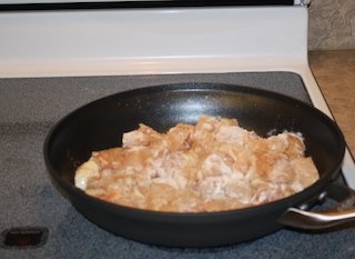 chicken browning on the stovetop in a large skillet