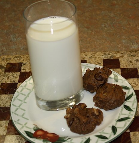 chocolate chip avocado cookies on a plate with a tall cool glass of milk.