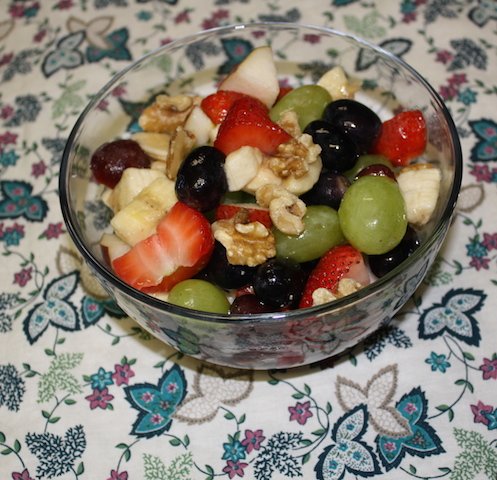 A nice bowl of fruit - strawberries, bananas, grapes, walnuts, blueberries so colorful and tasty