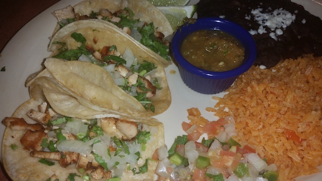 Chicken tacos with cheese vegetables and salsa served with rice and beans