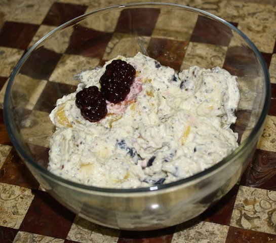 A bowl containing flaxseed oil combined with cottage cheese and fruit, topped with berries. so good and so good for you