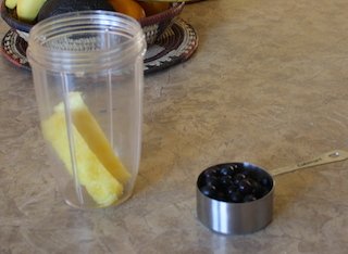 Put pineapple pieces in blender container and add blueberries