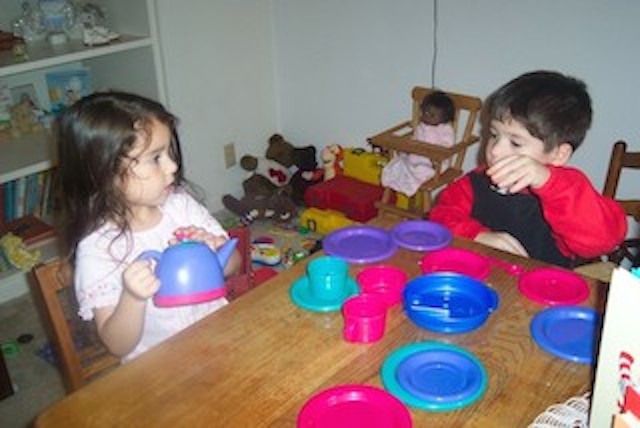 Two children having a make-believe tea part