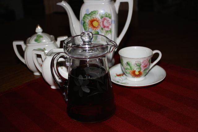 100% pure maple syrup in a glass etched decanter by a Japanese tea set