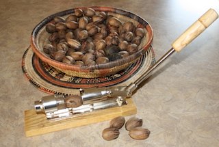 A basket of fresh pecans with a nut cracker, waiting to be cracked and eaten for good nutrition