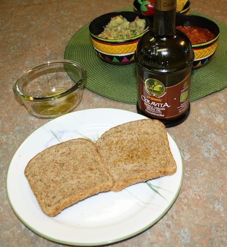 two pieces of sprouted grain bread spread with olive oil.