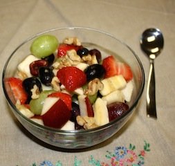 A clear glass bowl full of colorful cherries, nuts, bananas and more - colorful and delicious way to get antioxidants