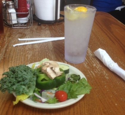 A healthy salad with kale, green peppers, mushrooms, and other vegetables