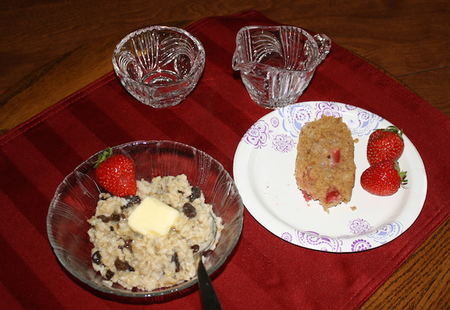 A creamy bowl of oatmeal with raisins and almonds and chia seeds served with strawberry bread for healthy cholesterol