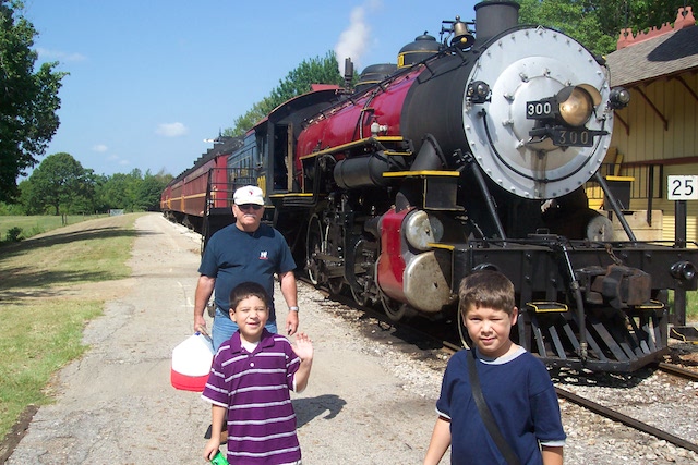 Caleb and Jared walking beside a train with their grandfather.